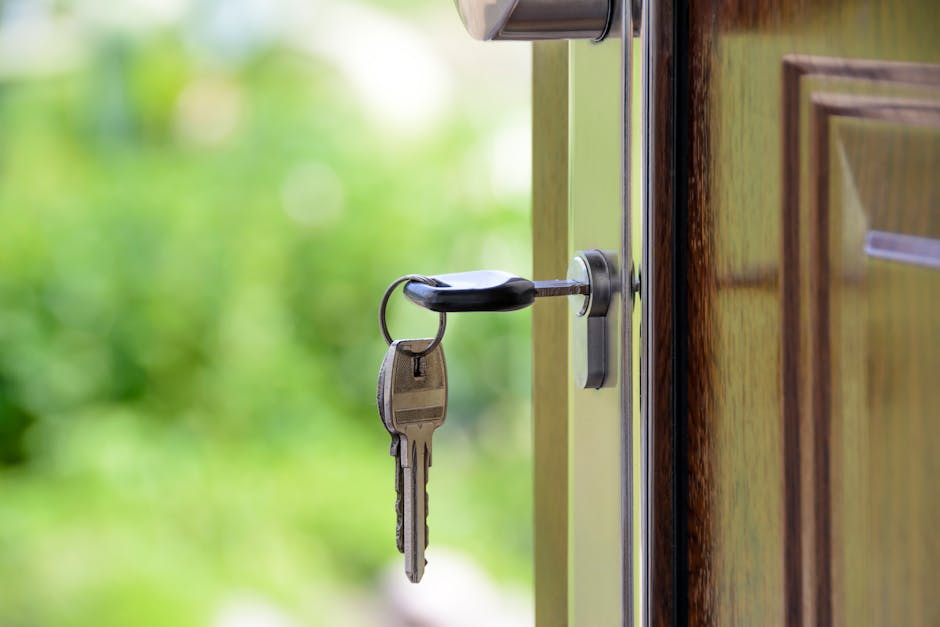 Key inserted in door lock against a blurred green background, symbolizing security and real estate